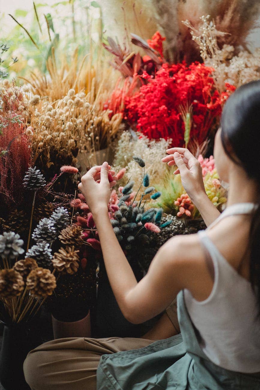crop woman choosing flowers for bouquet
